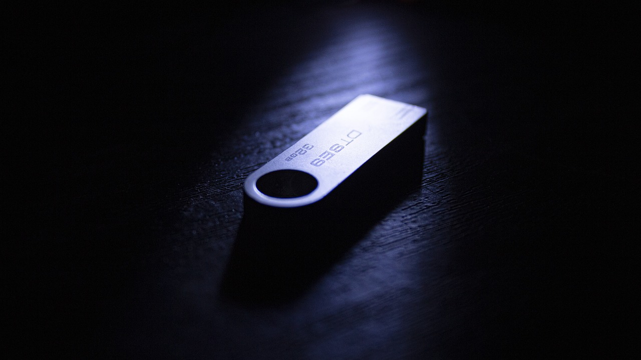 Uma pen USB de metal sobre uma superfície escura