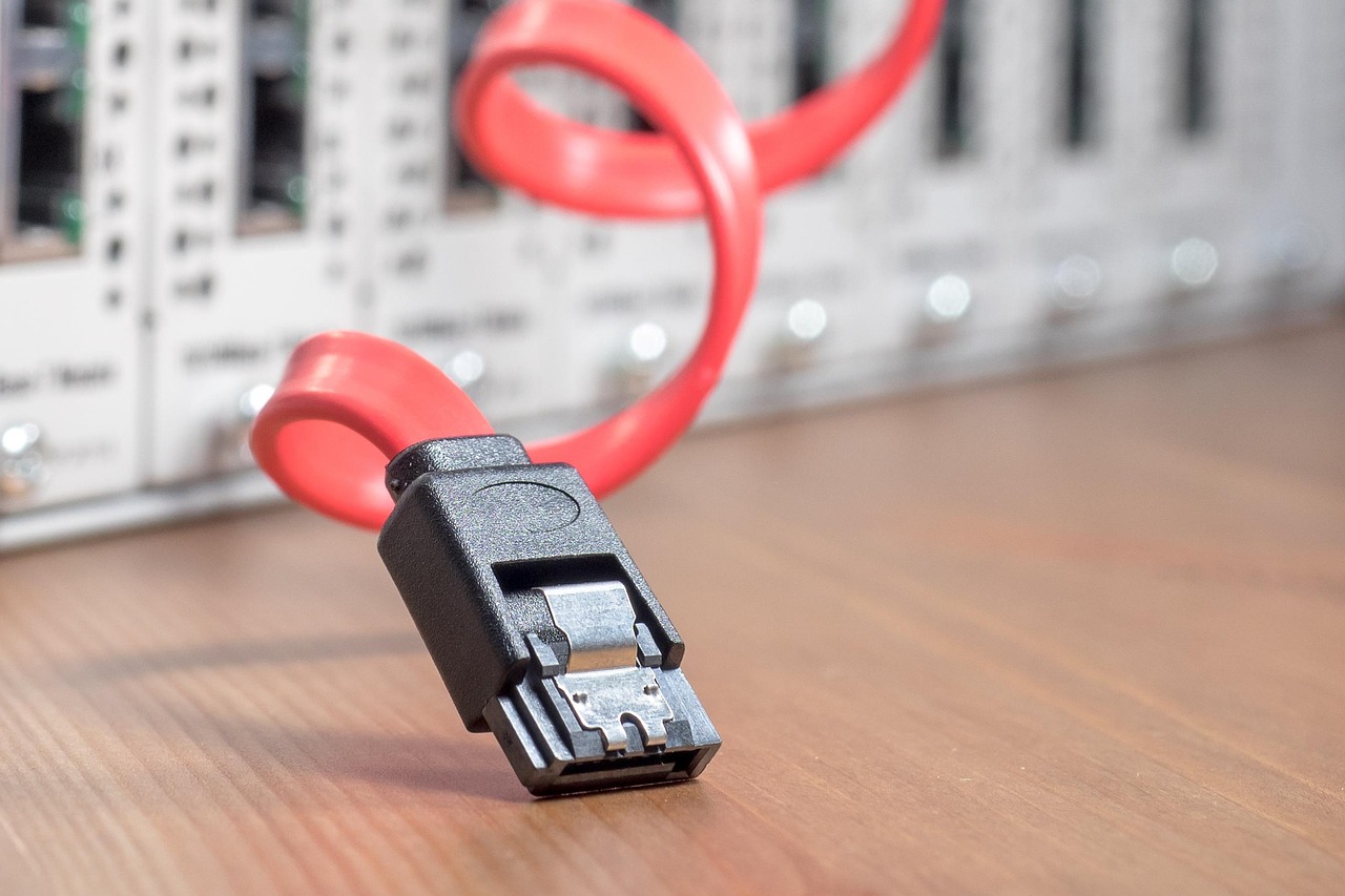 A red data cable in front of networking equipment — Tor relays your traffic through several servers before it reaches a site.