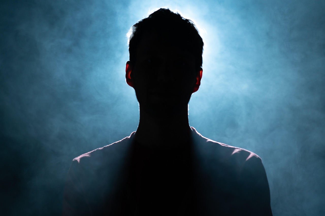 A backlit, unidentifiable silhouette — OPSEC is about controlling what others can learn and piece together about you.