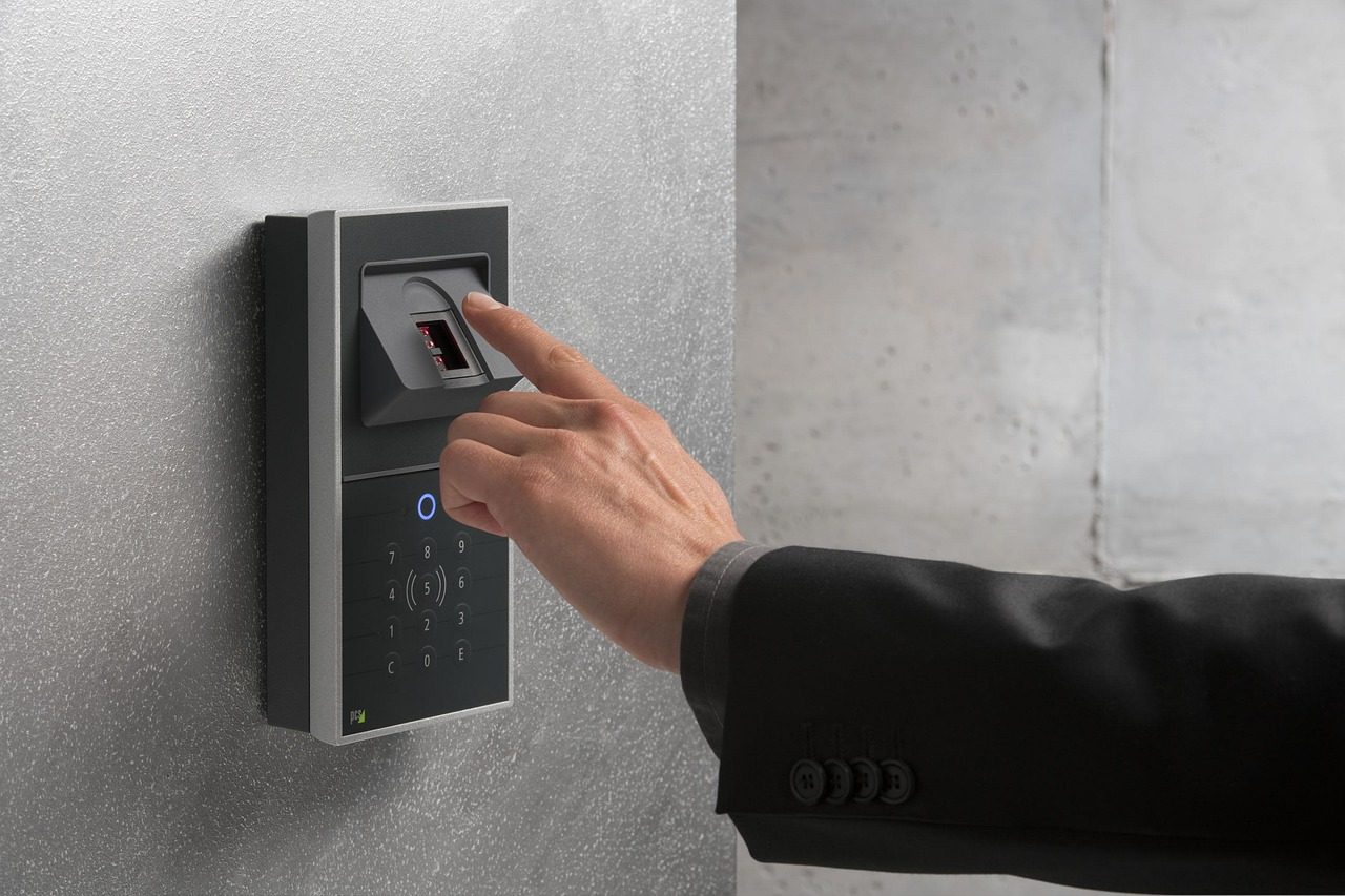 A finger touching a fingerprint sensor — biometrics are the "something you are" factor.